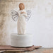 Ceramic angel figurine with wire wings on a textured surface