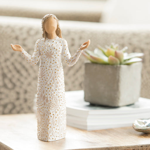 Decorative figurine of a woman in a white dress with lace details on a surface.
