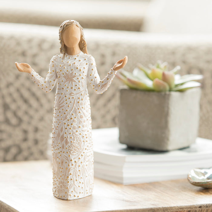 Decorative figurine of a woman in a white dress with lace details on a surface.