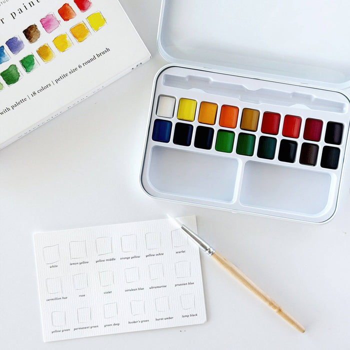 Watercolor paint set with color swatches on a white surface