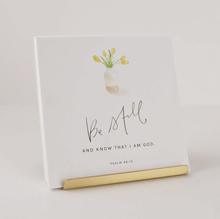 Notebook with 'Be Still and Know That I Am God' text and floral design on a light background