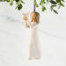 Decorative angel figurine holding a dove with greenery in the background