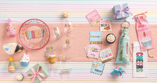Collection of birthday-themed party supplies on a striped background