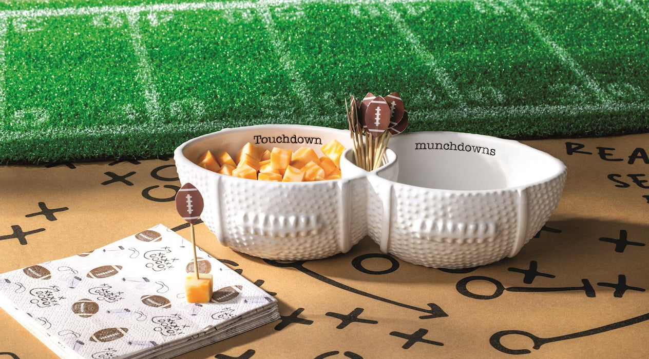 White divided bowl with snacks on a football-themed tablecloth