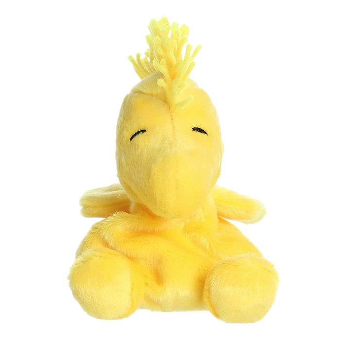 Yellow plush toy with a mohawk on a white background
