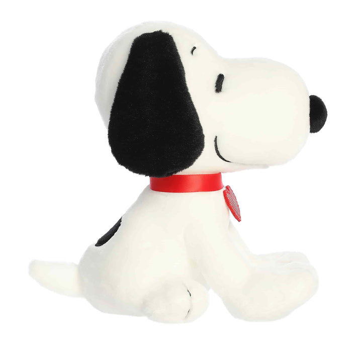 Plush toy resembling a dog with a black snout and red collar on a white background