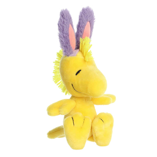 Yellow plush toy with purple and pink ears on a white background