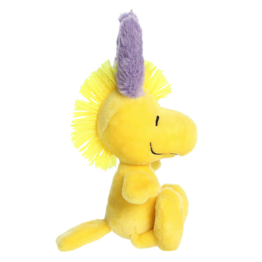Yellow plush toy with a purple mane on a white background