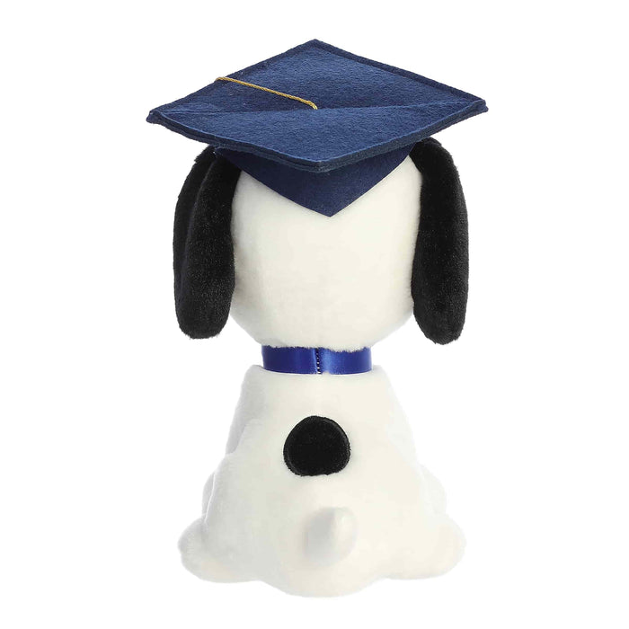 Stuffed dog toy wearing a blue graduation cap and gown on a white background