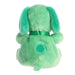Green plush toy with a bow on a white background