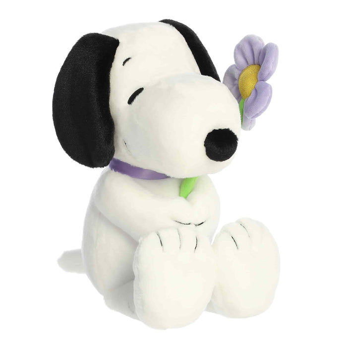 Plush toy of a dog with a flower on a white background