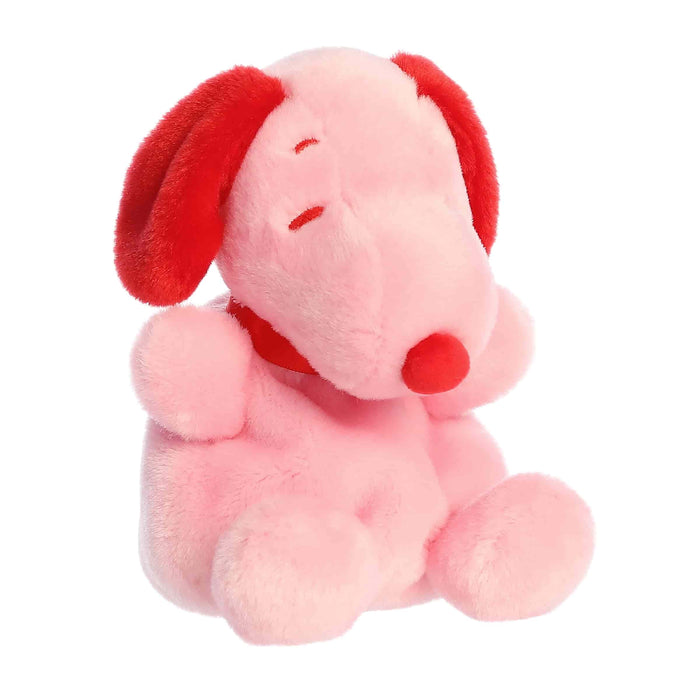 Pink plush dog toy with red ears on a white background