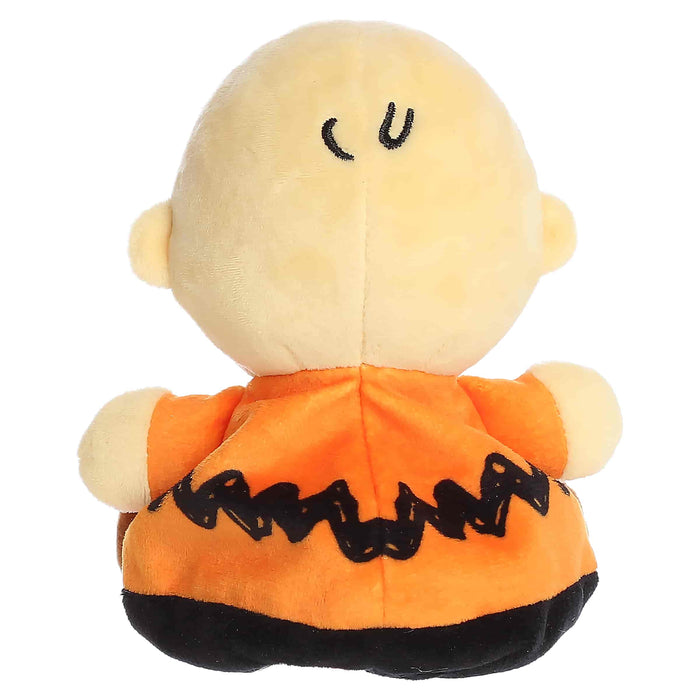Plush toy resembling a character with a bald head, orange shirt, and black pants on a white background