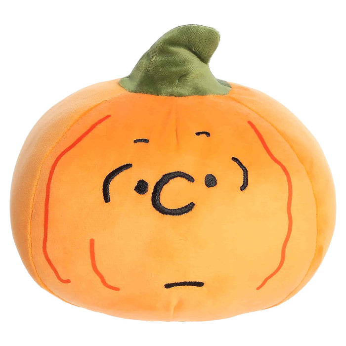 Plush pumpkin toy with a face on a white background