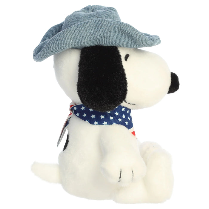 Snoopy plush toy with a cowboy hat and an American flag bandana on a white background