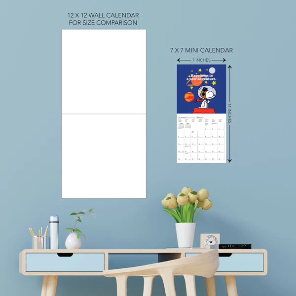 Comparison of a 12x12 wall calendar and a 7x7 mini calendar on a blue wall with a table and decor items.