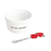 White bowl with text and a red pepper-themed spoon on a white background
