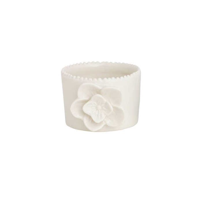 White ceramic cup with a floral design on a white background
