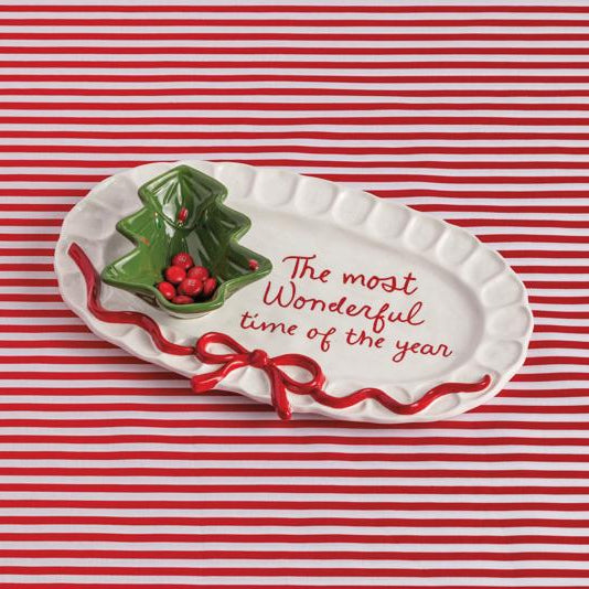 Decorative plate with holly design and text on a red and white striped background