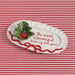 Decorative plate with holly design and text on a red and white striped background