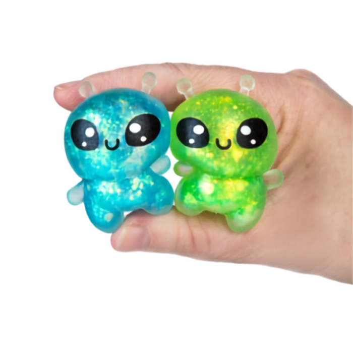 Two colorful alien-shaped squishies held in a hand against a white background