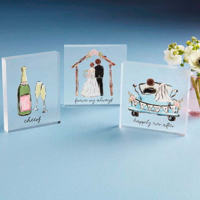 Three decorative glass blocks with wedding-themed illustrations on a gradient blue background.