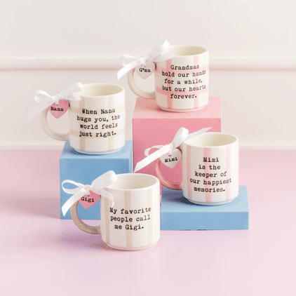 Set of mugs with humorous sayings on a pink surface