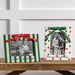 Two decorative picture frames with Christmas designs on a wooden surface.