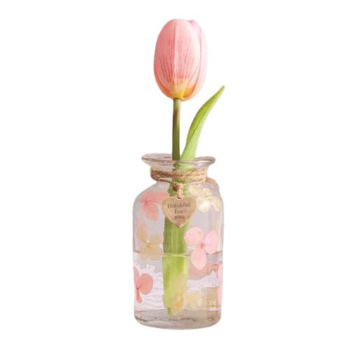 Glass jar with a pink tulip inside on a white background
