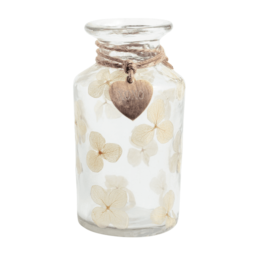 Glass jar with dried flowers and a heart-shaped tag on a white background