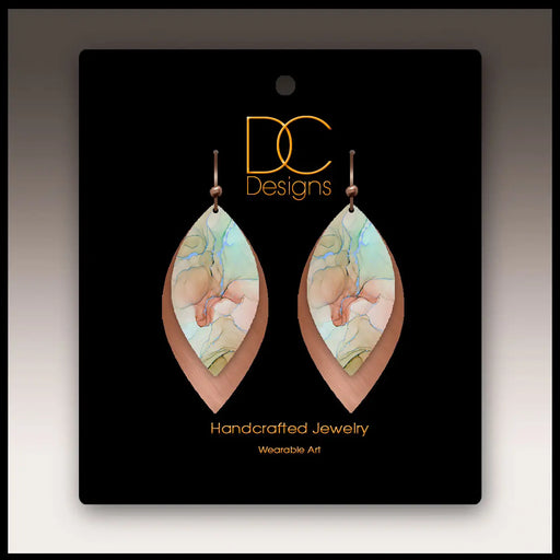 Pair of handcrafted earrings on a black card with 'DC Designs' branding.
