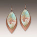 Pair of teardrop-shaped earrings with artistic design on a neutral background