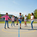 Children playing on a school playground with a clear blue sky.