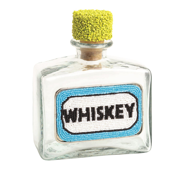Small glass bottle labeled 'Whiskey' with a yellow cork on a white background