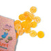 Orange candy pieces with a pink box featuring a character on a white background