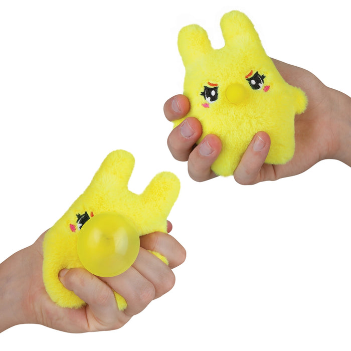 Two yellow plush bunny toys with cartoon faces held by hands on a white background