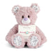 Pink teddy bear with a bracelet on a white background