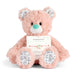 Pink teddy bear with a gymnastics-themed bracelet and card on a white background