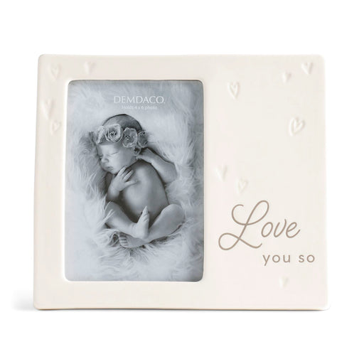 White photo frame with 'Love you so' text containing a baby photo, Demdaco brand visible.