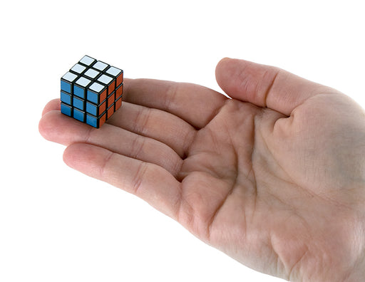 Small Rubik's Cube held in a hand on a white background