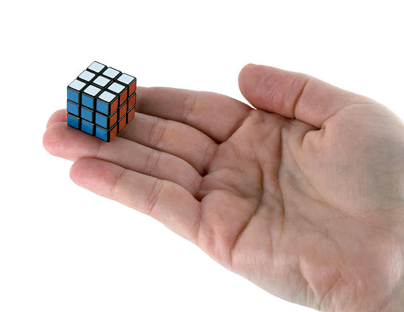 Small Rubik's Cube held in a hand on a white background