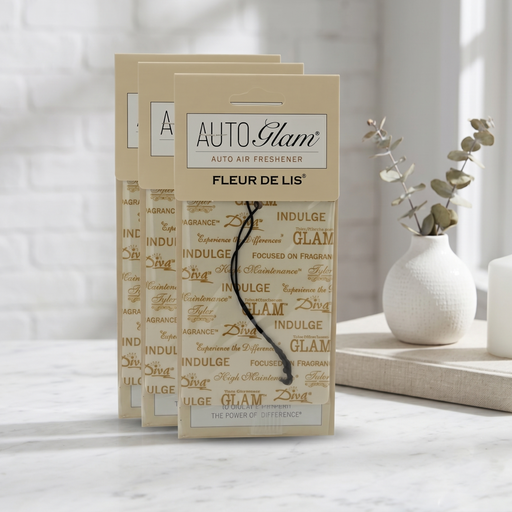 Auto Glam auto air freshener packaging on a marble surface with a blurred background