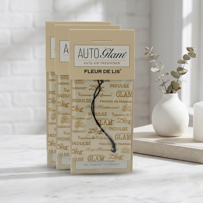 Auto Glam auto air freshener packaging on a marble surface with a blurred background