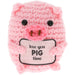 A pink crocheted plush pig toy holding a sign that reads 'love you PIG time' in black text, set against a plain white background.