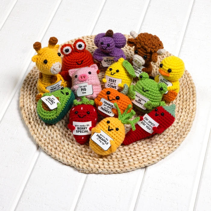 Colorful crochet animals with labels on a woven mat