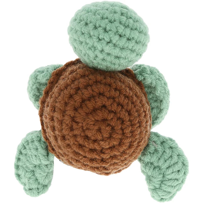 Crocheted turtle toy with green body and brown shell on a white background