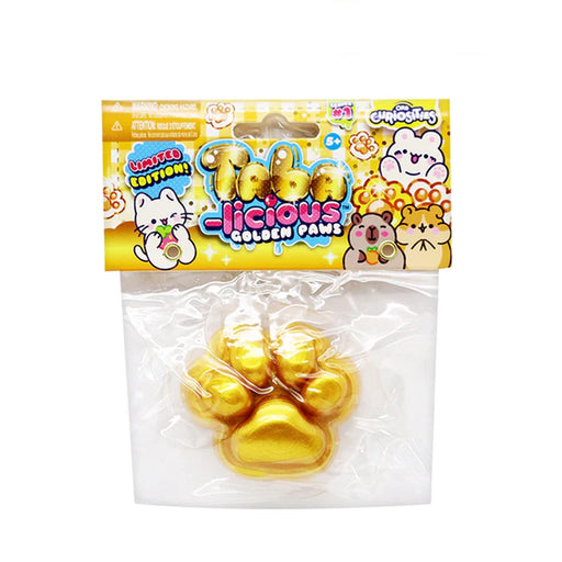 A packaged novelty item labeled 'Licious Golden Paws' in a clear plastic bag with a colorful printed header card. Inside are four shiny gold paw-shaped items, likely chocolate or candy, on a plain white background.