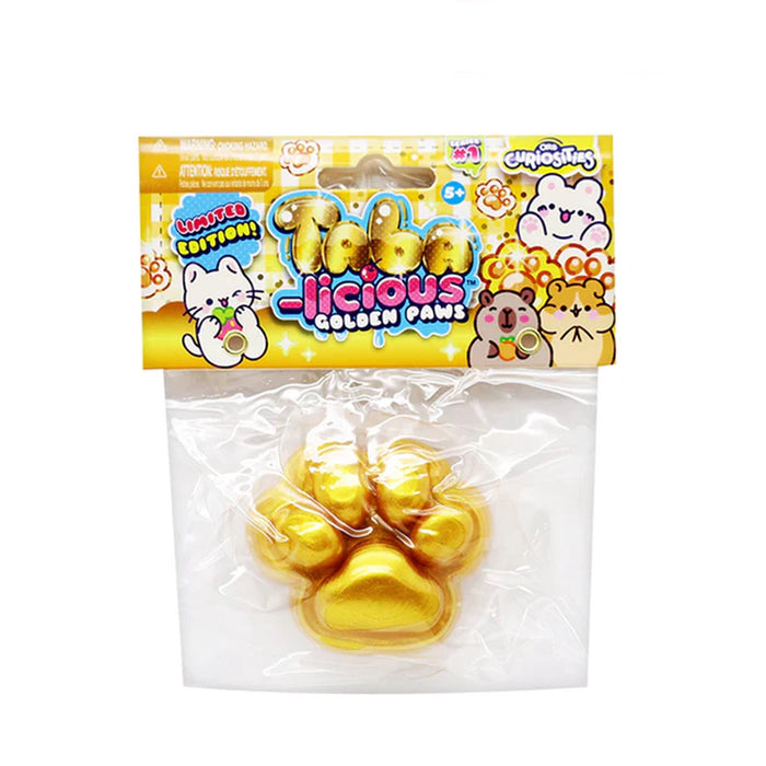 A packaged novelty item labeled 'Licious Golden Paws' in a clear plastic bag with a colorful printed header card. Inside are four shiny gold paw-shaped items, likely chocolate or candy, on a plain white background.