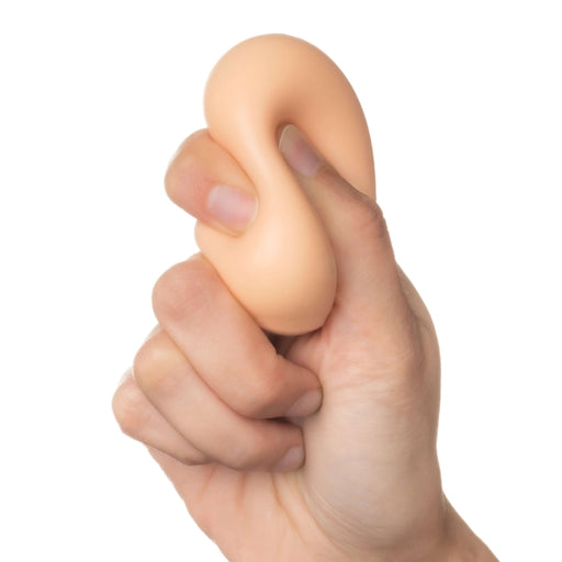 Hand holding a beige-colored stress ball against a white background