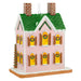Decorative gingerbread house ornament with pink walls, green roof, and yellow windows on a white background.